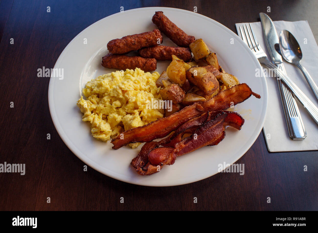 Scrambled Eggs With Breakfast Sausage Home Fries And Bacon Stock Photo Alamy
