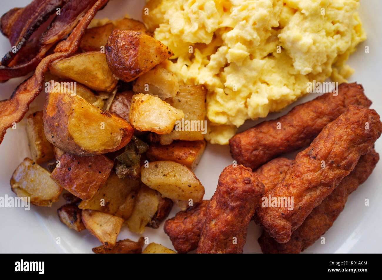 Scrambled Eggs With Breakfast Sausage Home Fries And Bacon Stock Photo Alamy