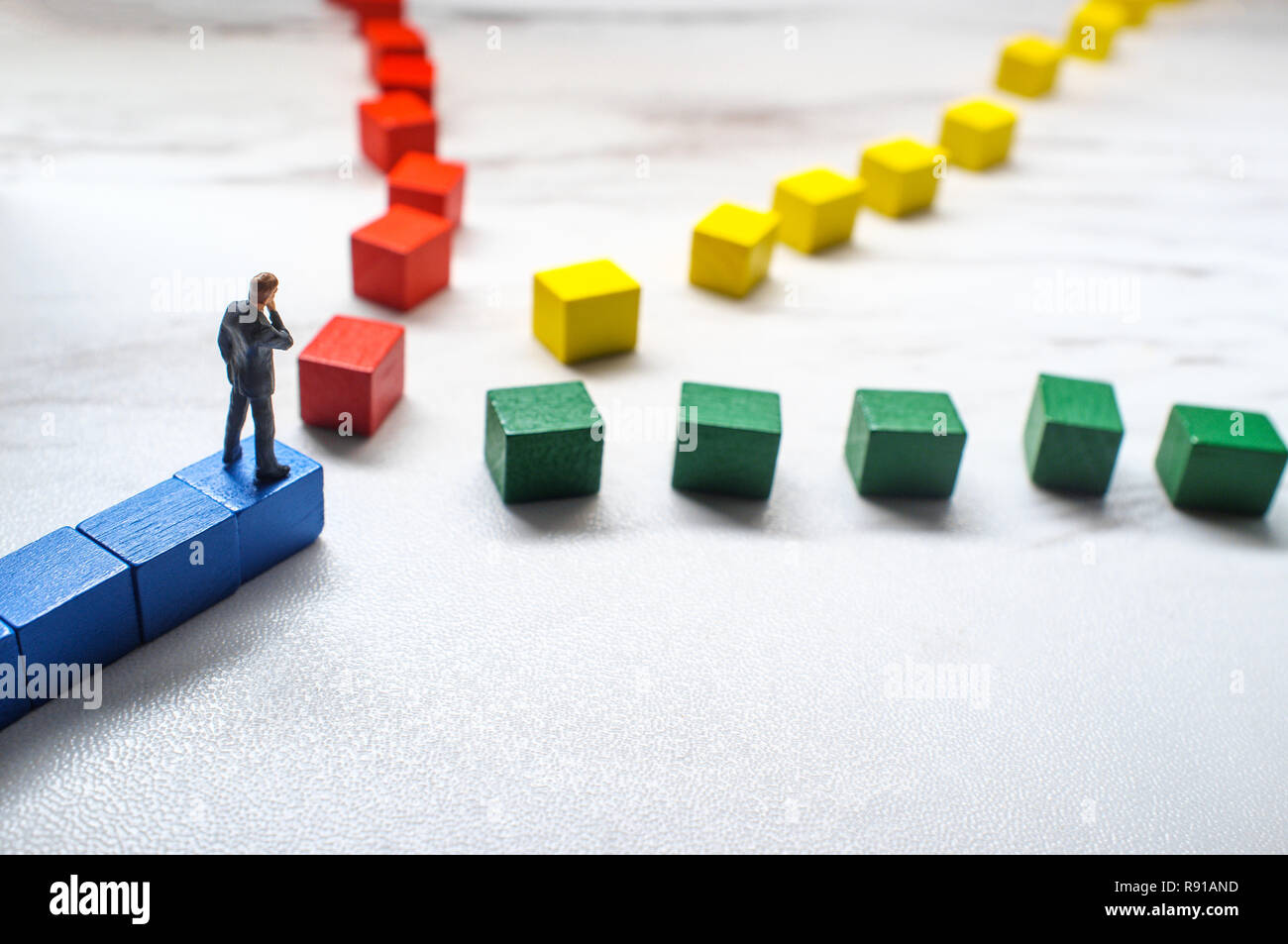 Miniature businessmen trying to pick the path to success down three