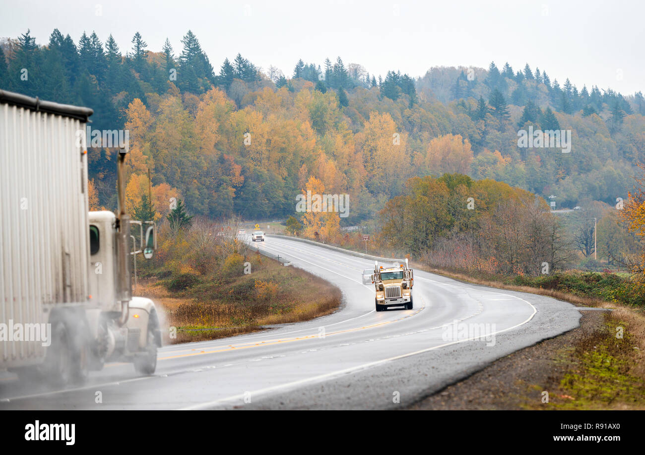 Two big rigs semi trucks one tip truck and one with bulk trailer move