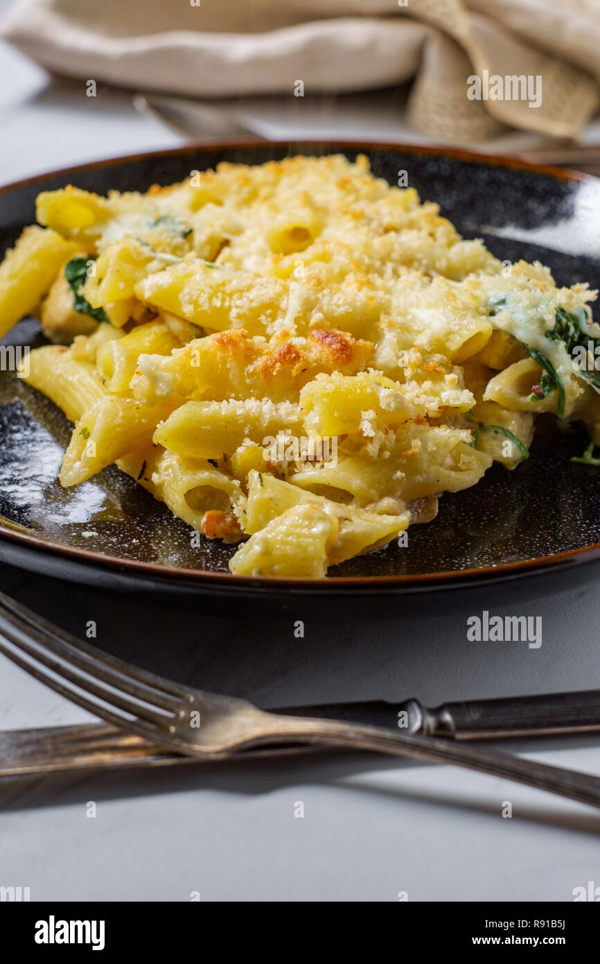 Creamy baked chicken alfredo with penne pasta topped with parmesan and
