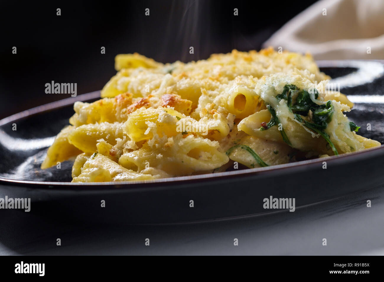 Creamy baked chicken alfredo with penne pasta topped with parmesan and