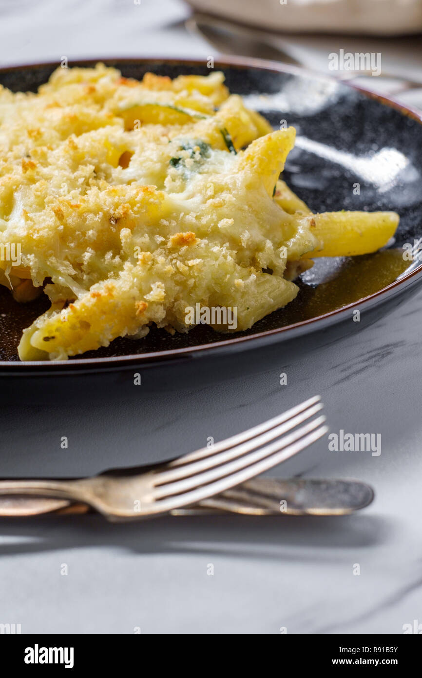 Creamy baked chicken alfredo with penne pasta topped with parmesan and