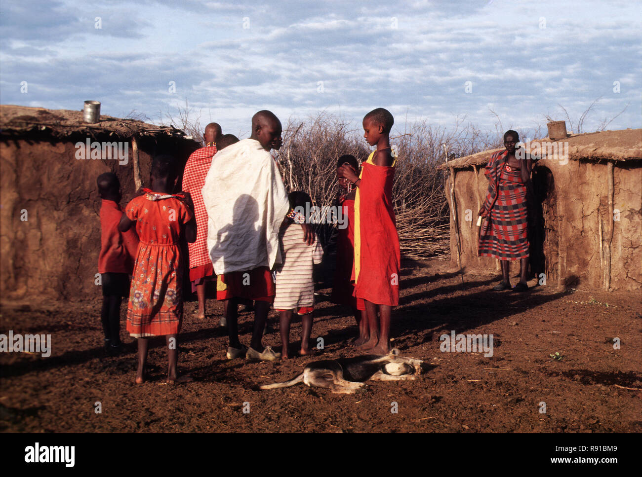 Masai tribesmen near their houses inside a manyatta, Masai Mara Game Reserve, Kenya. Masais are maybe the most famous of all african tribes, Kenya Stock Photo