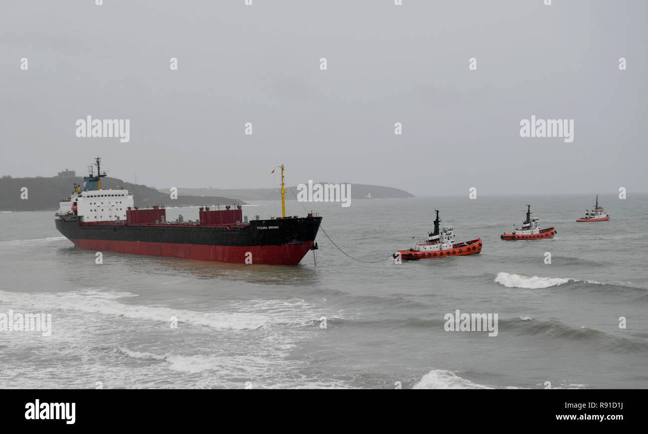 Tugs manoeuvre the Kuzma Minin, a 16,000-tonne Russian cargo ship, as attempts are made to refloat it after it ran aground off Gyllyngvase Beach in Falmouth. Stock Photo