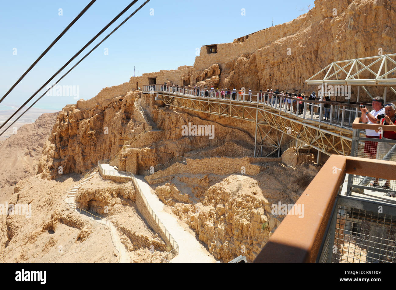 Touring Masada rock plateau with ruined palaces of brutal King Herod in Judaean Desert of Israel reminding mass suicide of Jews fighting with Romans. Stock Photo