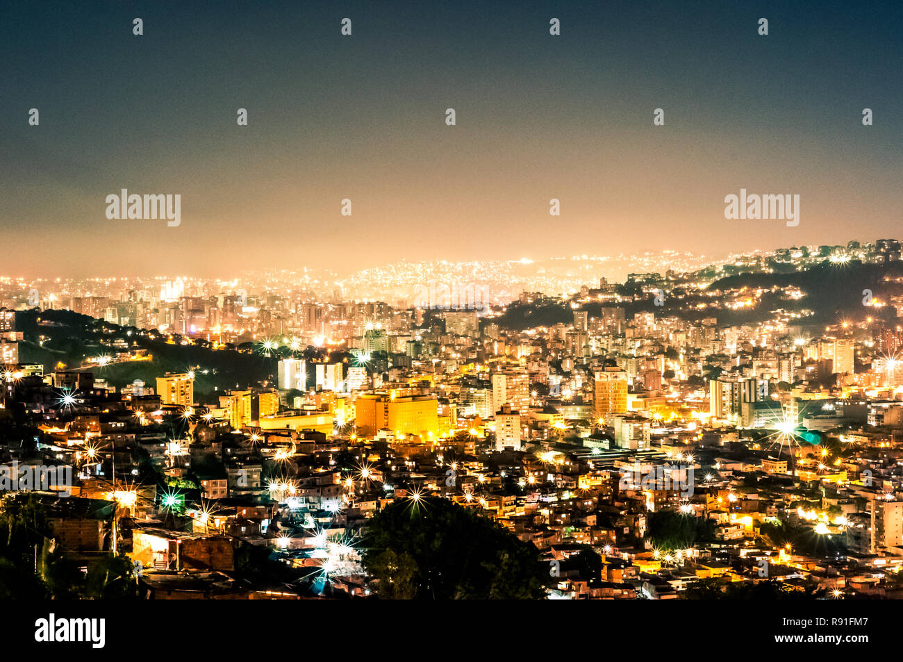 night view cityscape of caracas during summer clear sky with view of hills with the slums, so called barrios Stock Photo