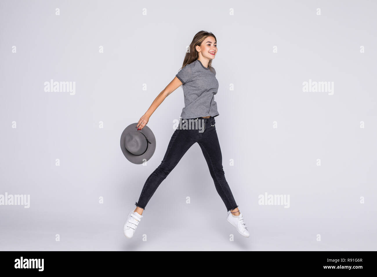Full length portrait of a cheerful cute woman jumping isolated on a ...