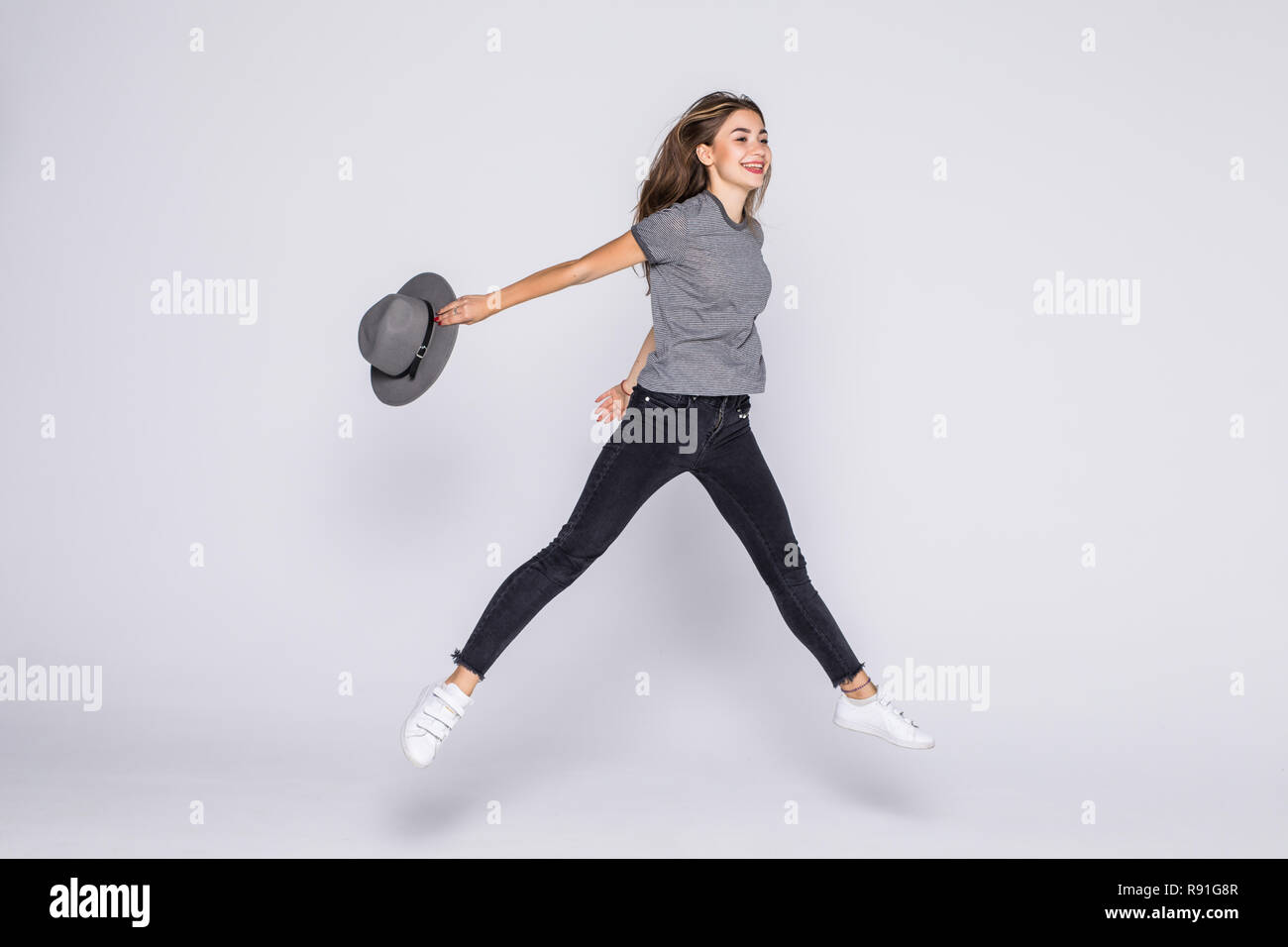 Full length portrait of a cheerful cute woman jumping isolated on a ...