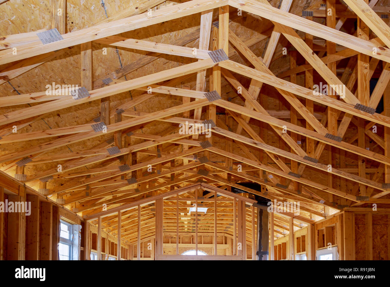 Close-up new stick built home under construction under blue sky Framing structure wood frame of wooden houses home. Stock Photo