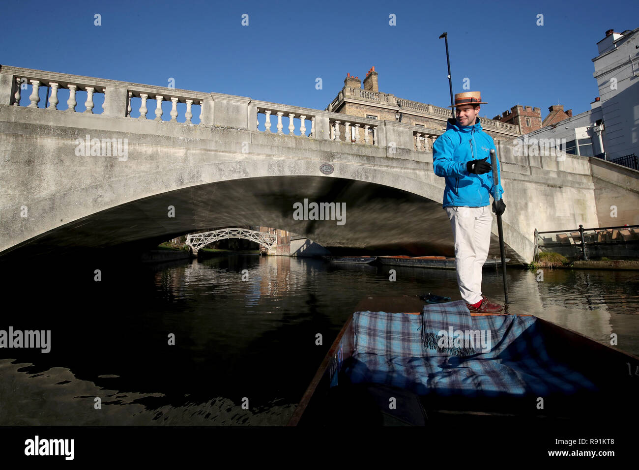 A punt chauffeur makes his way  along the river Cam in Cambridge. Stock Photo