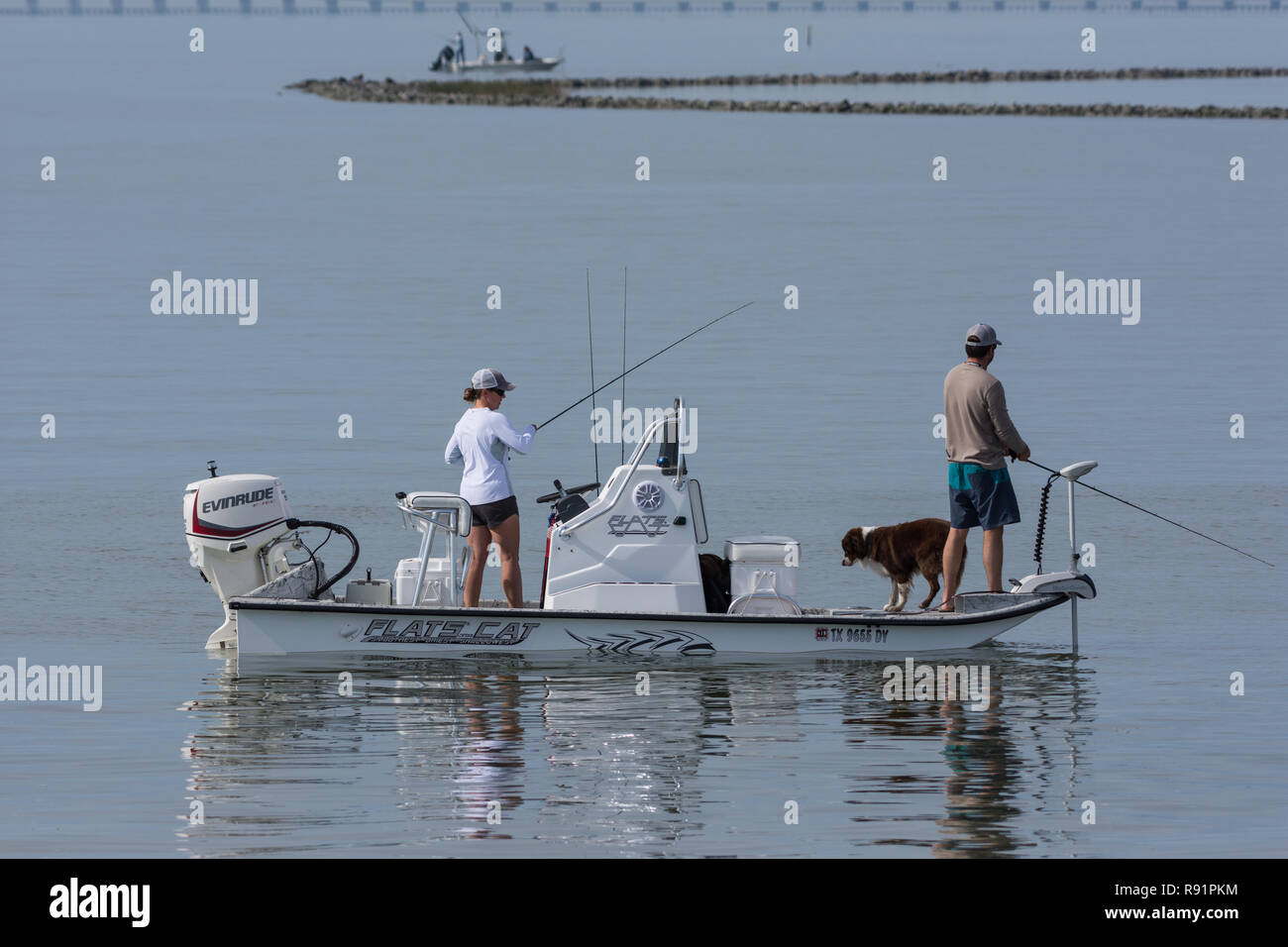 A couple fishing on a boat with their dog. Aransas National Wildlife
