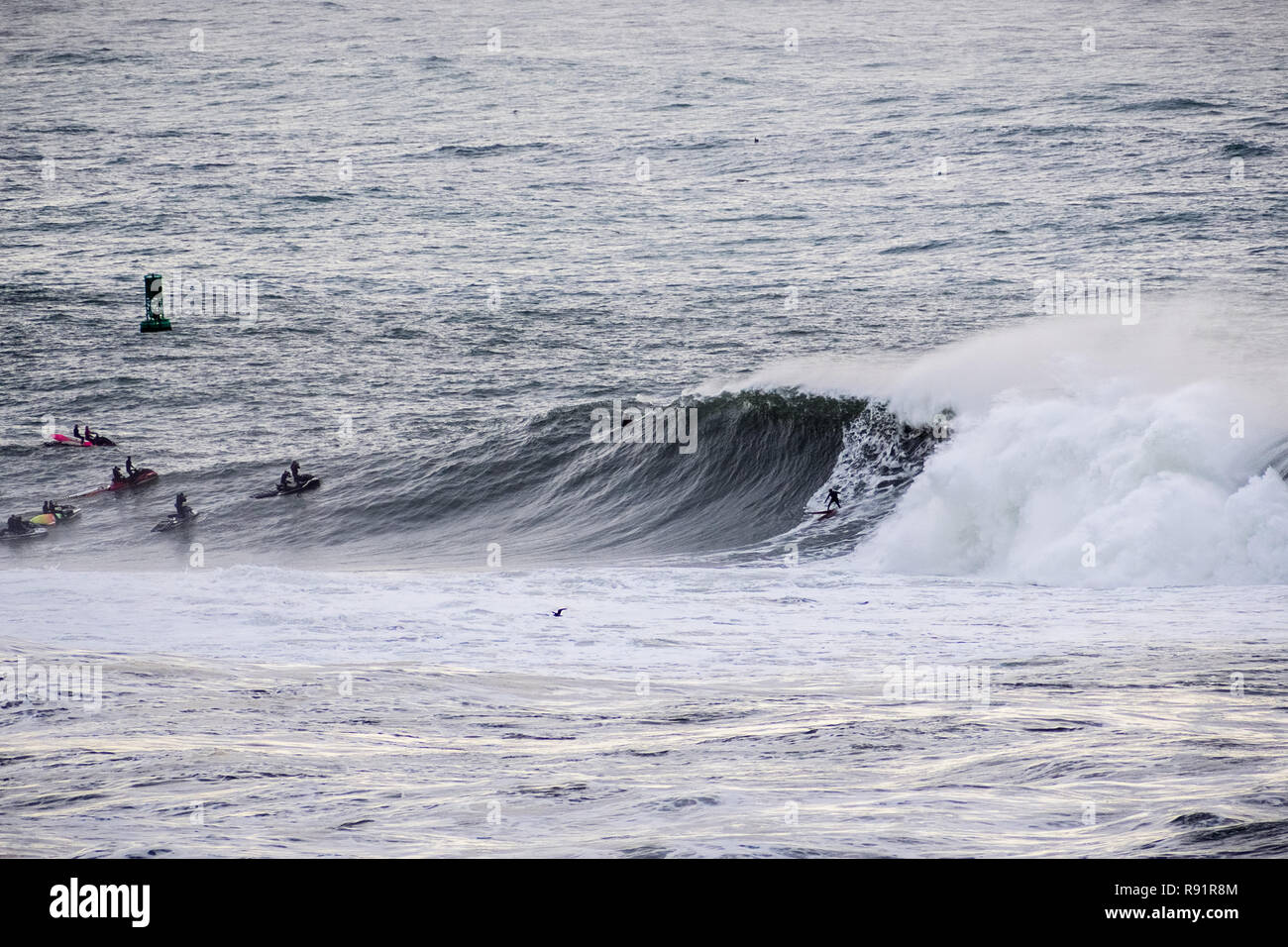 Surfers riding huge waves on the west coast, close to Pillar Point and Mavericks Beach, Half Moon Bay, California Stock Photo