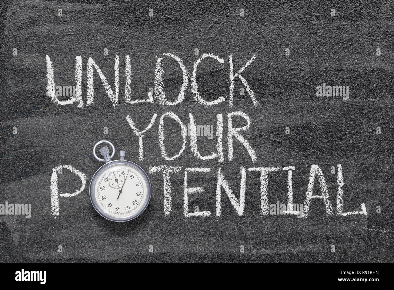 unlock your potential phrase handwritten on chalkboard with vintage precise stopwatch used instead of O Stock Photo