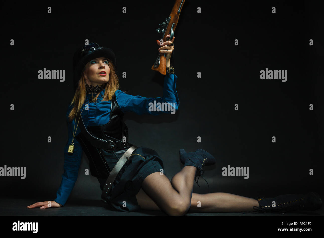 Subculture fashionable victorian elegant weapon concept. Steampunk girl armed and dangerous. Lady dressed in victorian fashion holding antique firearm Stock Photo
