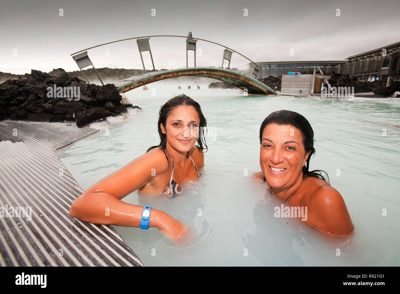 Photograph of two women in relaxing in a hot spring and smiling at camera, Blue Lagoon, Keflavik, Iceland Stock Photo