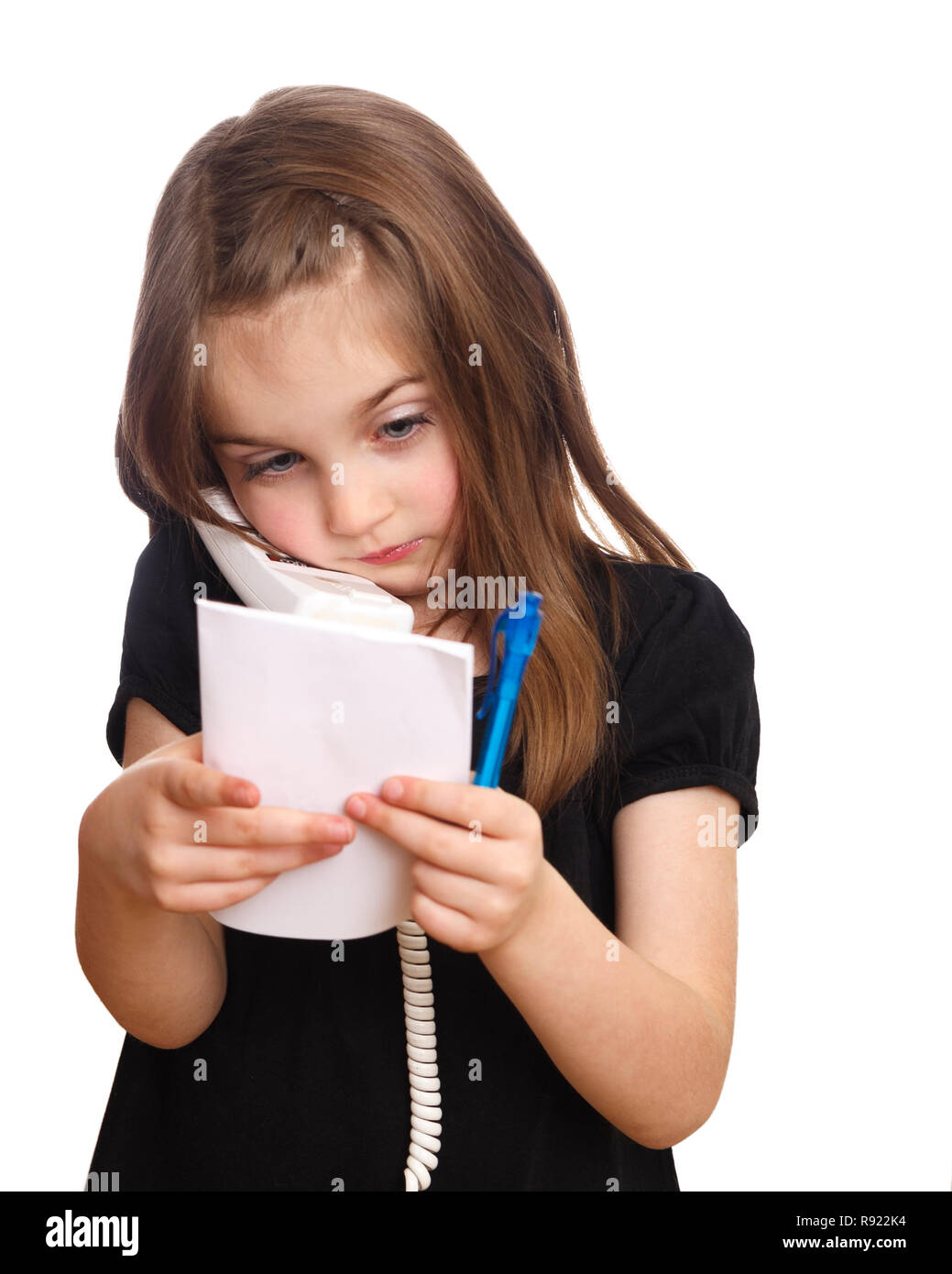 Cute young girl on the phone listening and taking notes on notepad Stock Photo