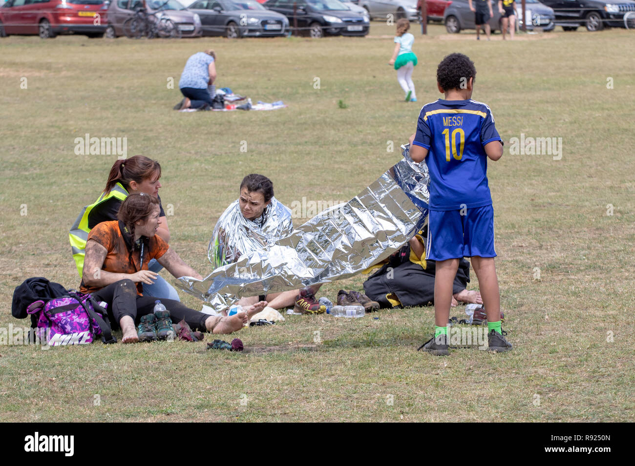 Mud runners are given foil blankets after the event Stock Photo