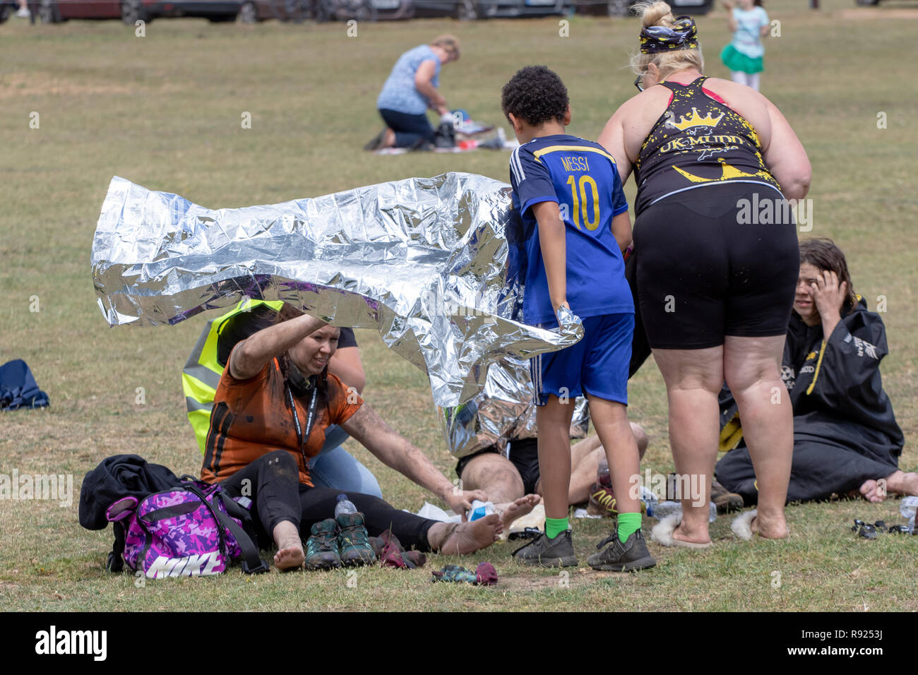 Mud runners are given foil blankets after the event Stock Photo