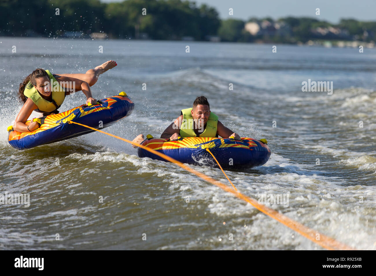 Young man and woman tubing together on Fox River in summer, De Pere