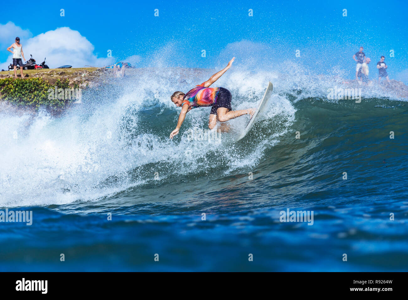 Mid adult male surfer riding wave in sea, Jimbaran, Bali, Indonesia Stock Photo
