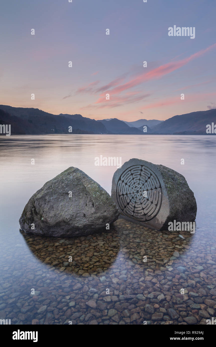 The Millenium Stone in the shallows of Derwent Water near Keswick, looking towards Borrowdale on a cold, clear Winter's morning in the Lake District. Stock Photo