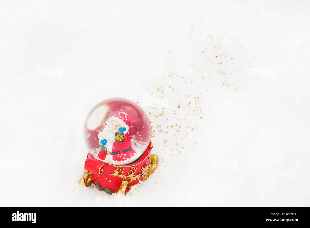 Funny cute Santa Claus in a snow globe on the snow - Christmas decoration concept Stock Photo