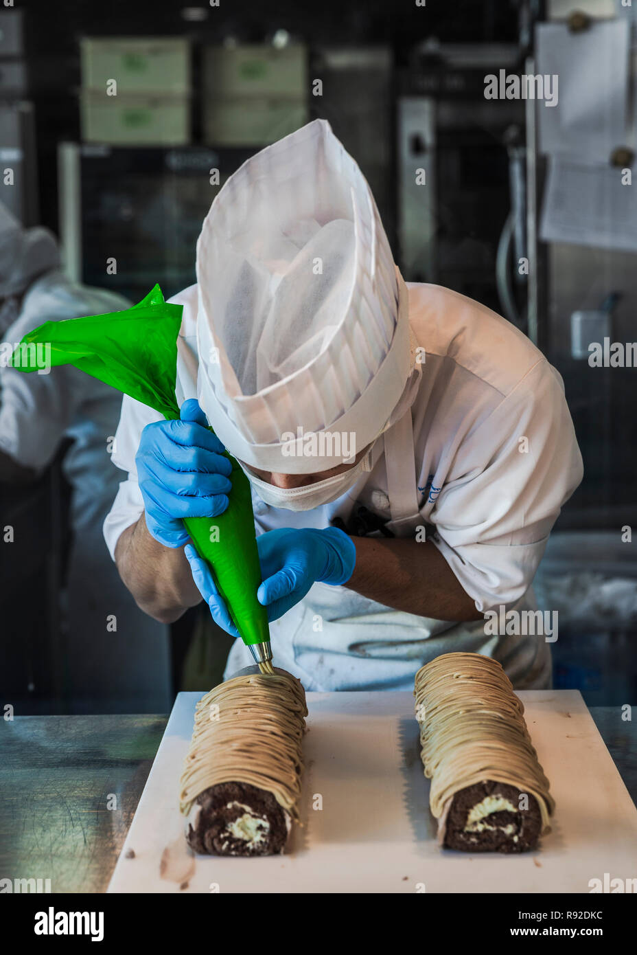 A Japanese pastry chef while garnishing some cake rolls. Otaru