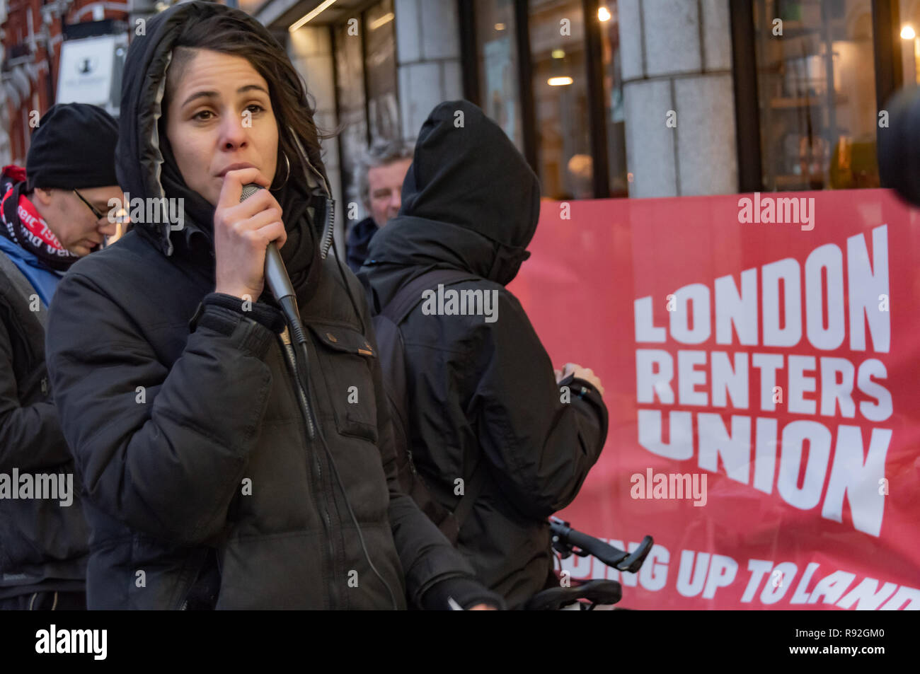 London, UK. 18th December 2018. A speaker from Berlin community centre and pub Syndikat at the protest with London Renters Union outside the London offices of their landlord, Global Real Estate Investors Limited, owned by the secretive Pears brothers, three of the richest men in the UK, who through various 'letterbox' companies own around 6200 properties in Berlin, against notice to quit after being open for 33 years in Berlin-Neukölln. Credit: Peter Marshall/Alamy Live News Stock Photo