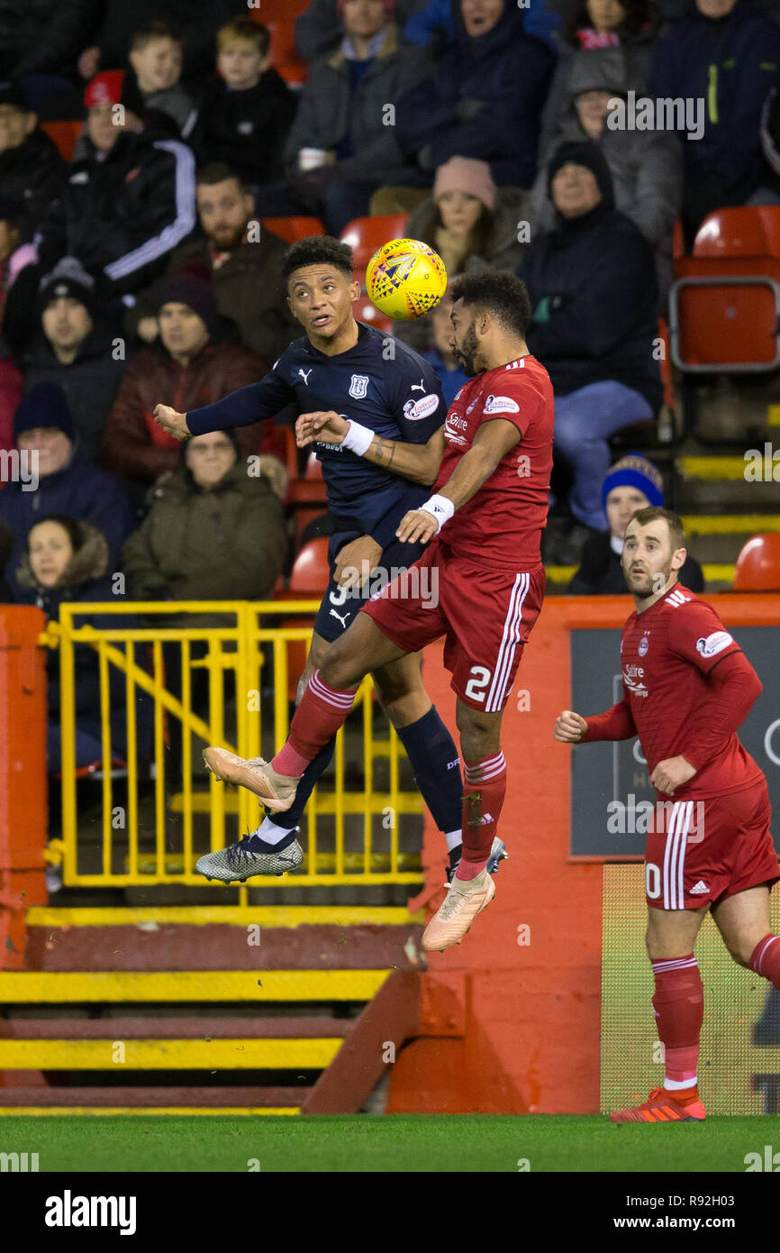 Pittodrie Stadium, Aberdeen, UK. 18th Dec, 2018. Ladbrokes Premiership football, Aberdeen versus Dundee; Nathan Ralph of Dundee competes in the air with Shaleum Logan of Aberdeen Credit: Action Plus Sports/Alamy Live News Stock Photo