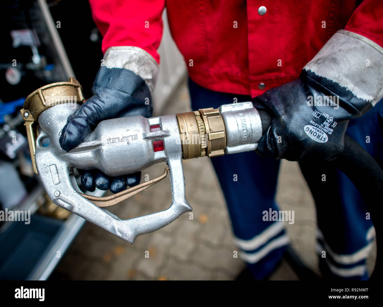 25 November 2018, Lower Saxony, Visselhövede: A delivery driver on the premises of a heating oil supplier is holding the nozzle of a tank truck for the delivery of heating oil in his hands. Photo: Hauke-Christian Dittrich/dpa Stock Photo