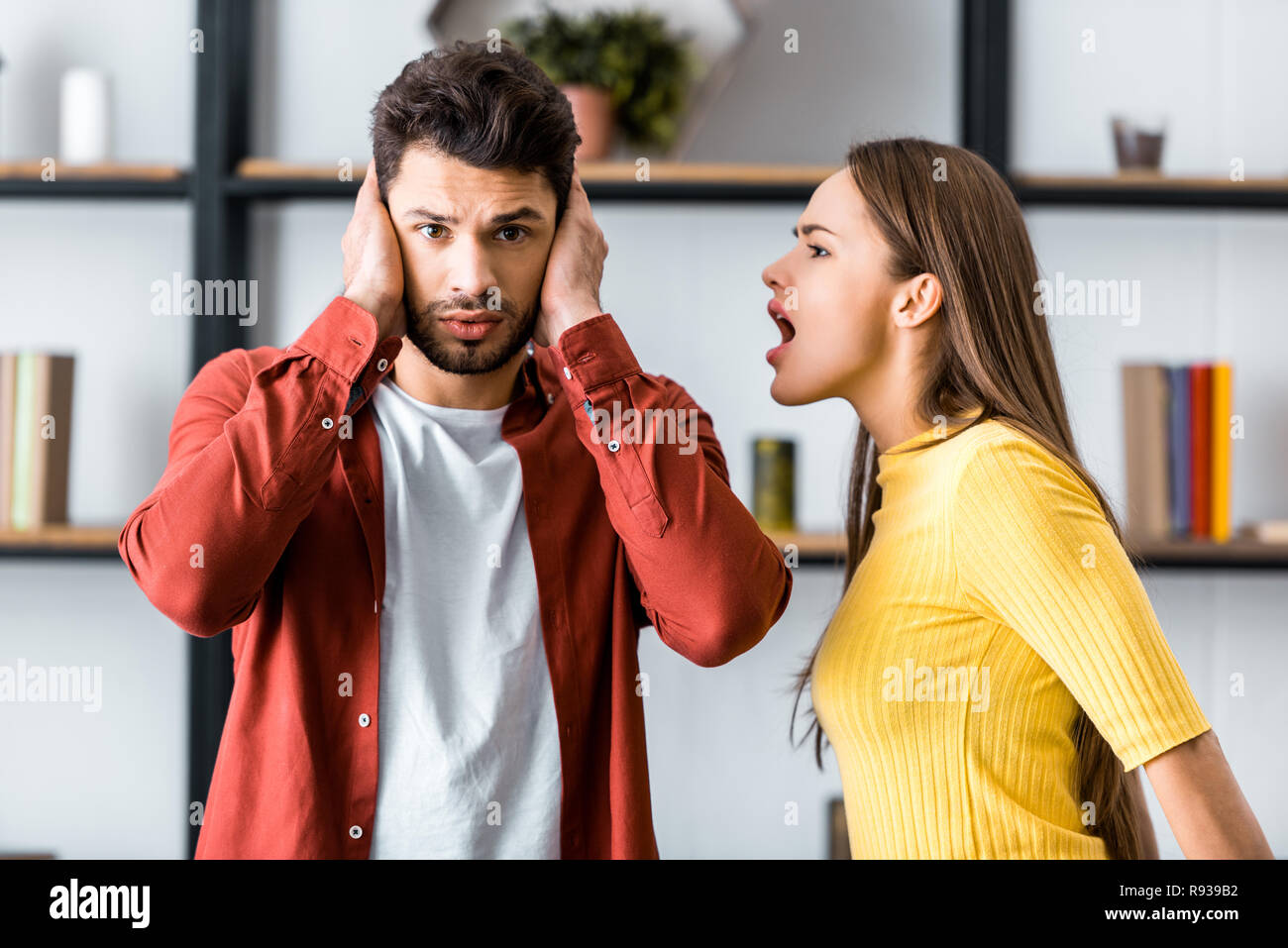Selective Focus Of Angry Girlfriend Screaming At Boyfriend While Man Putting Hands On Ears Stock Photo Alamy