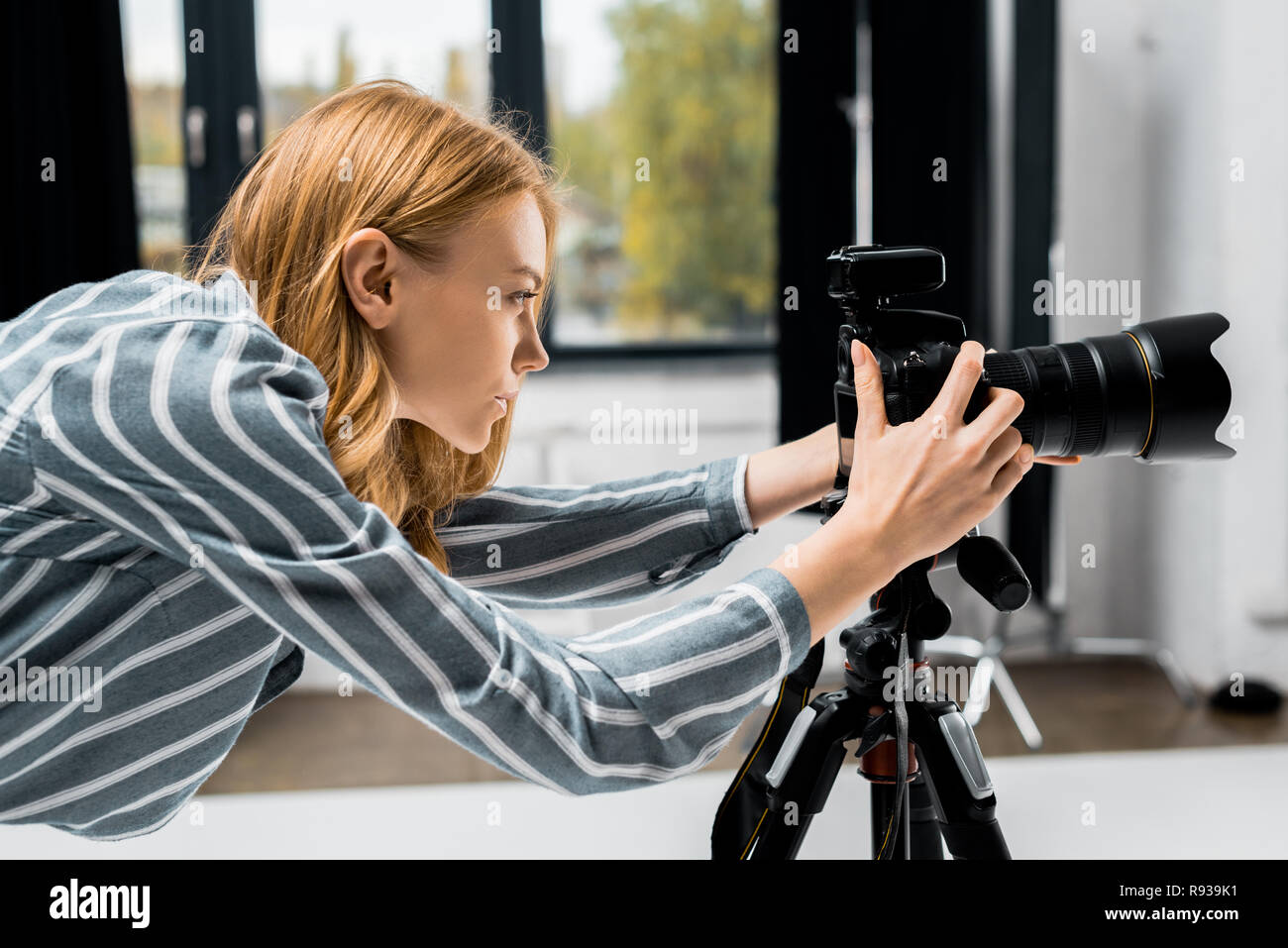 side view of young female photographer working with professional photo side view of young female photographer working with professional photo