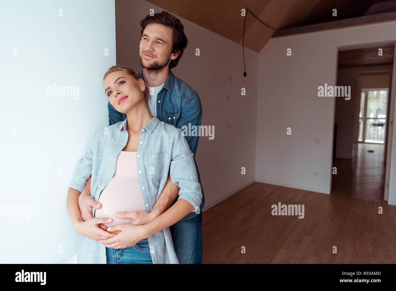 thoughtful man embracing pregnant wife in apartment Stock Photo - Alamy