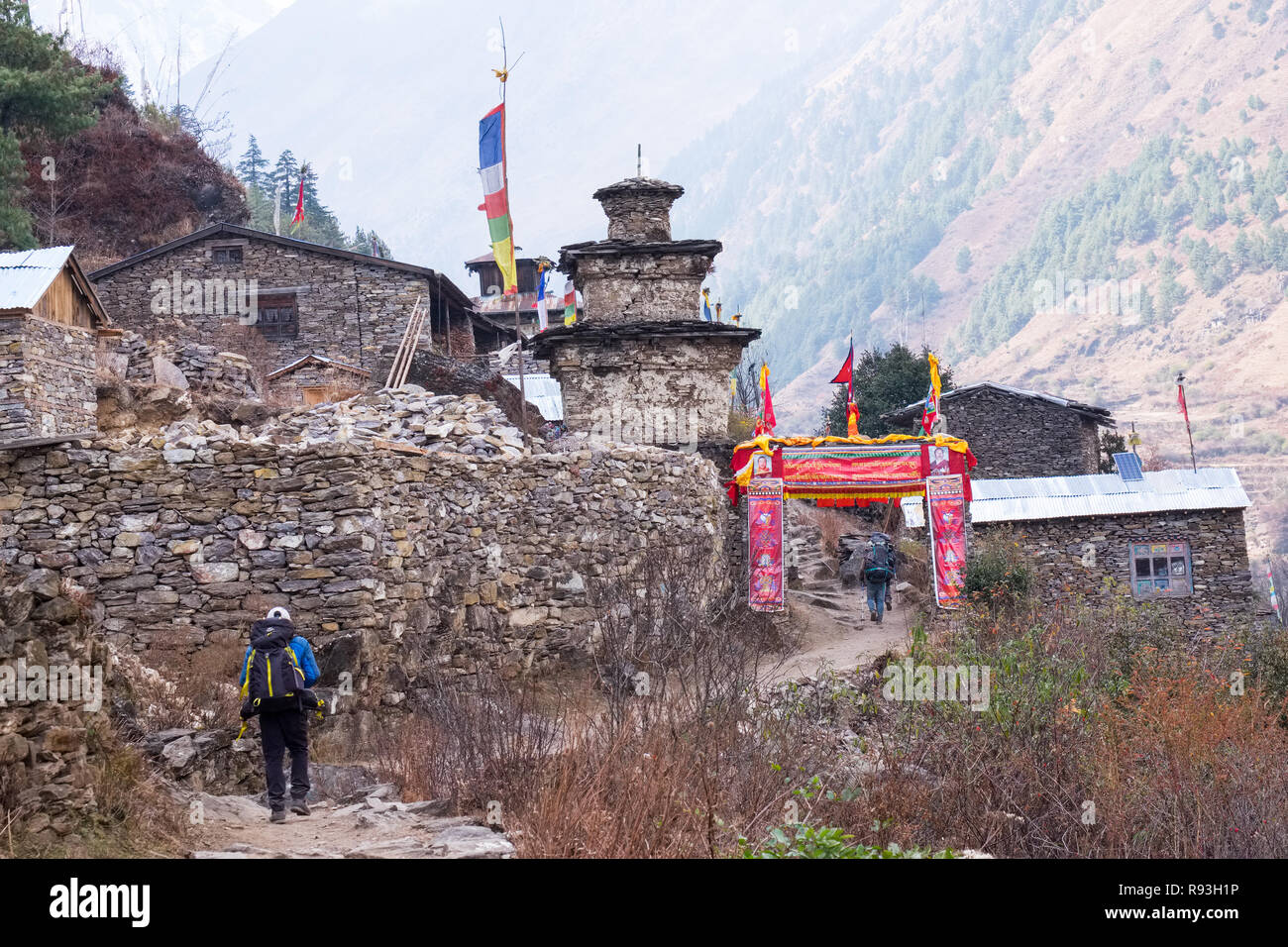 Trekkers entering the village of Ghap on the Manaslu Circuit, Nepal Stock Photo