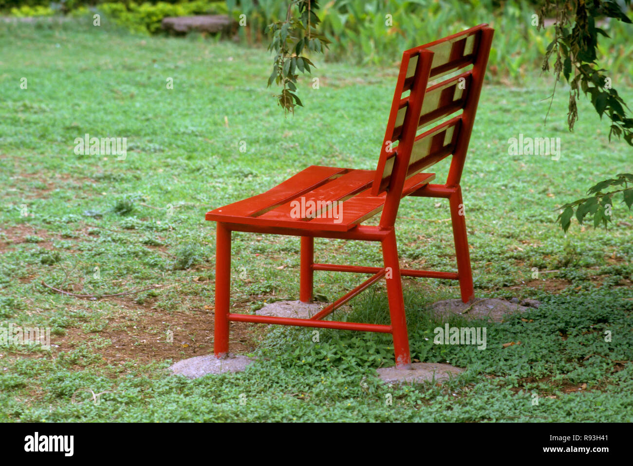 Red wooden bench in garden Stock Photo