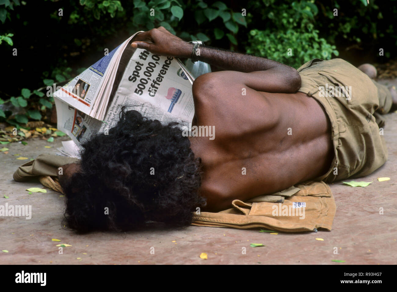 Beggars reading English Newspaper Stock Photo