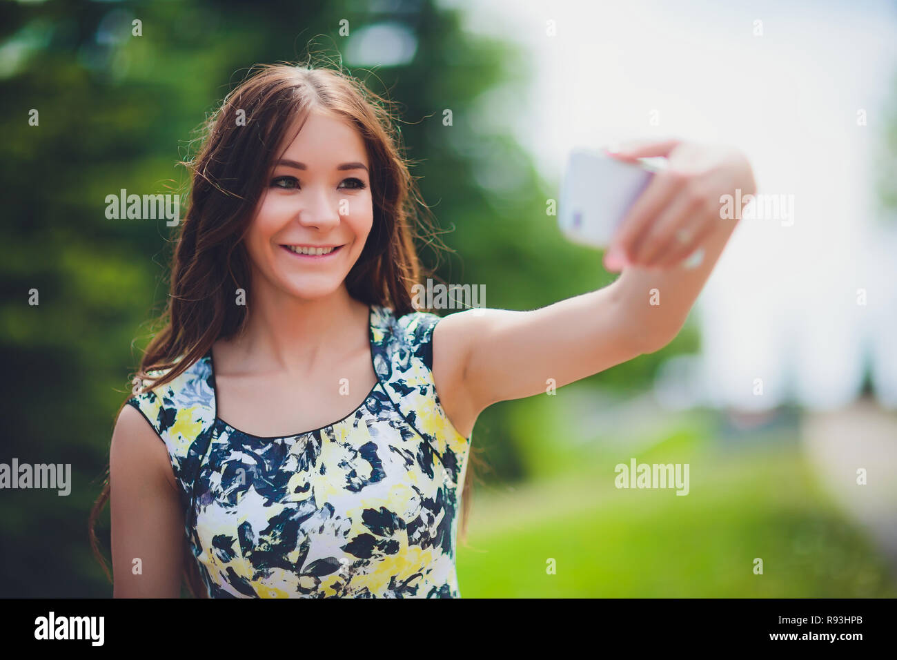 Close up sunny portrait of young happy pretty girl making selfie and ...