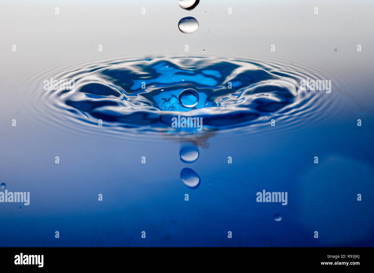 Blue water droplet making a splash Stock Photo
