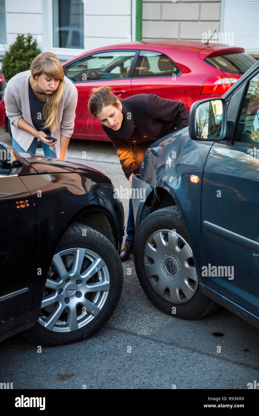 Traffic accident, slight body damage to a car, crash while turning from an exit, accident participants discussing who is at Stock Photo