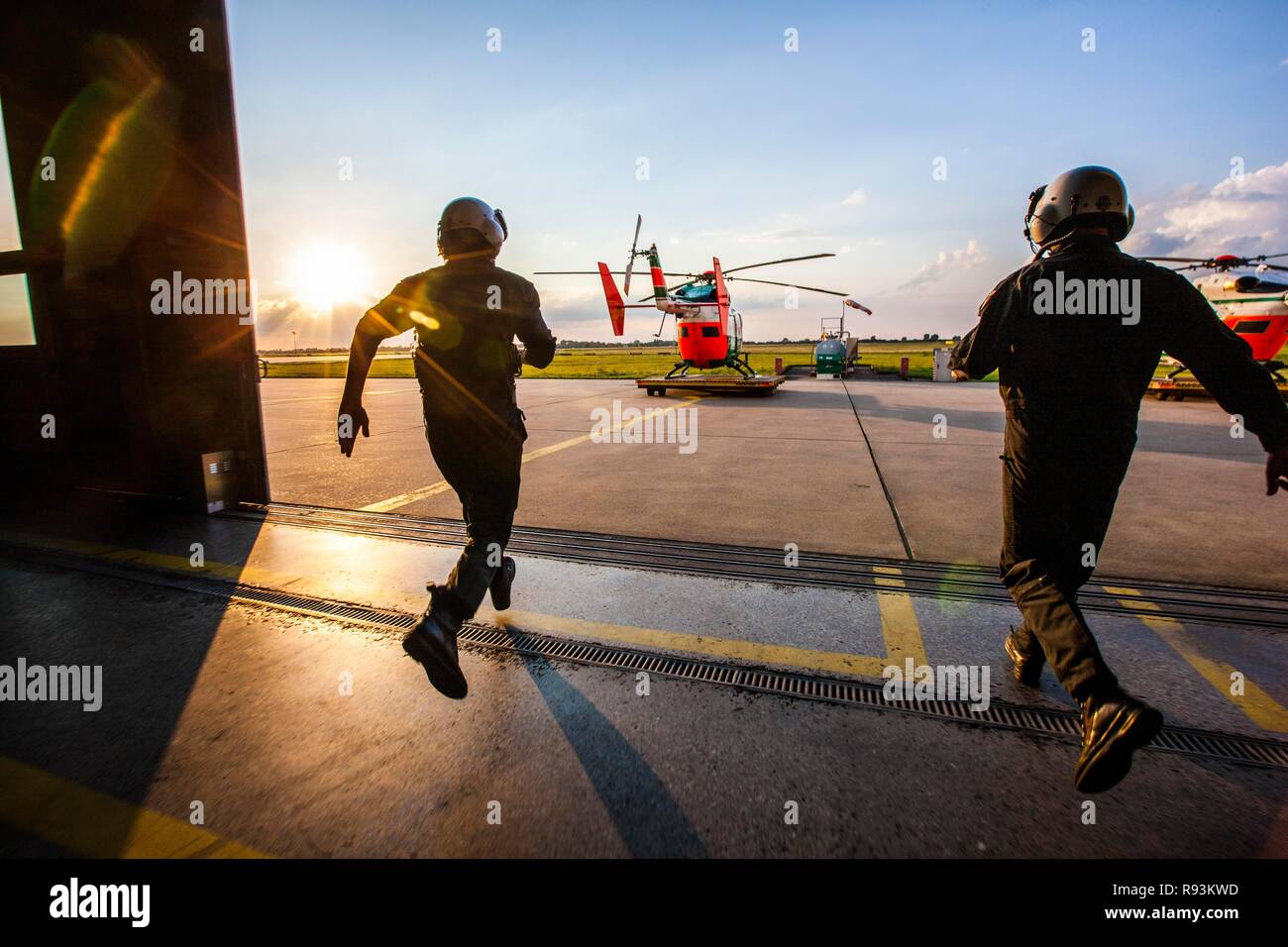 Pilots sprinting towards a helicopter, emergency start, police helicopter type BK 117, Police Flying Squadron NRW Stock Photo