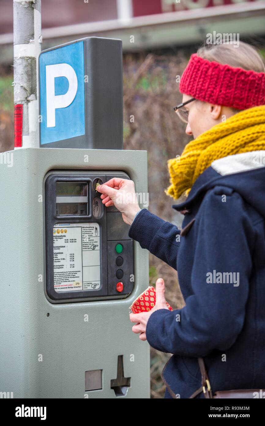 Woman purchasing a parking ticket from a parking ticket vending machine ...