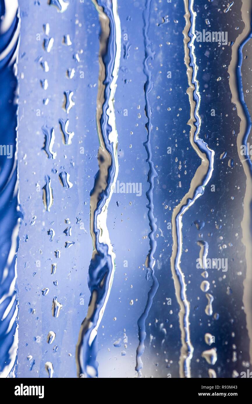 Water running down a sheet of glass, water consumption, wasting water Stock Photo