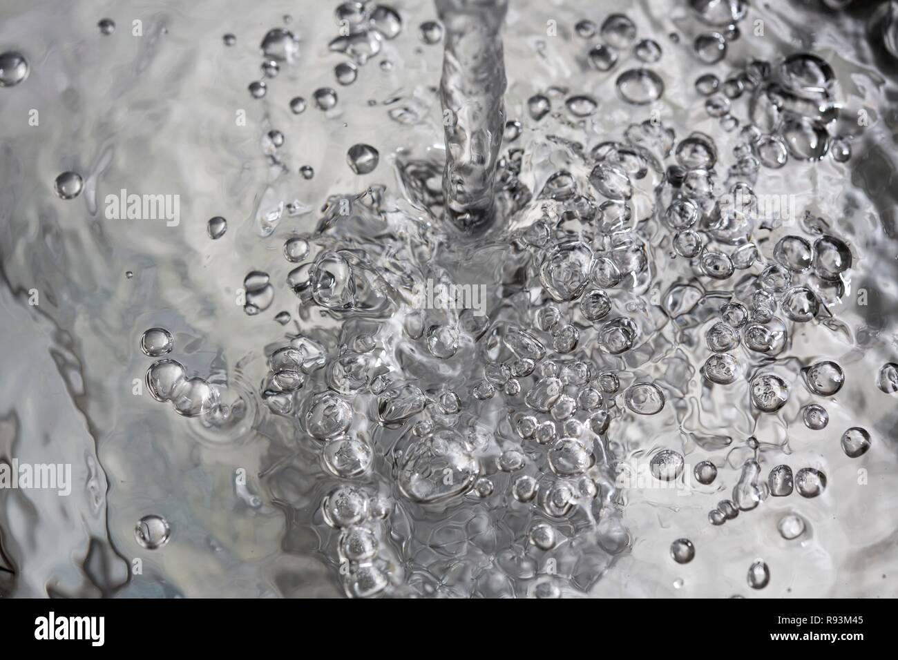 Water flowing into a basin, symbolic image for water consumption, wasting water Stock Photo
