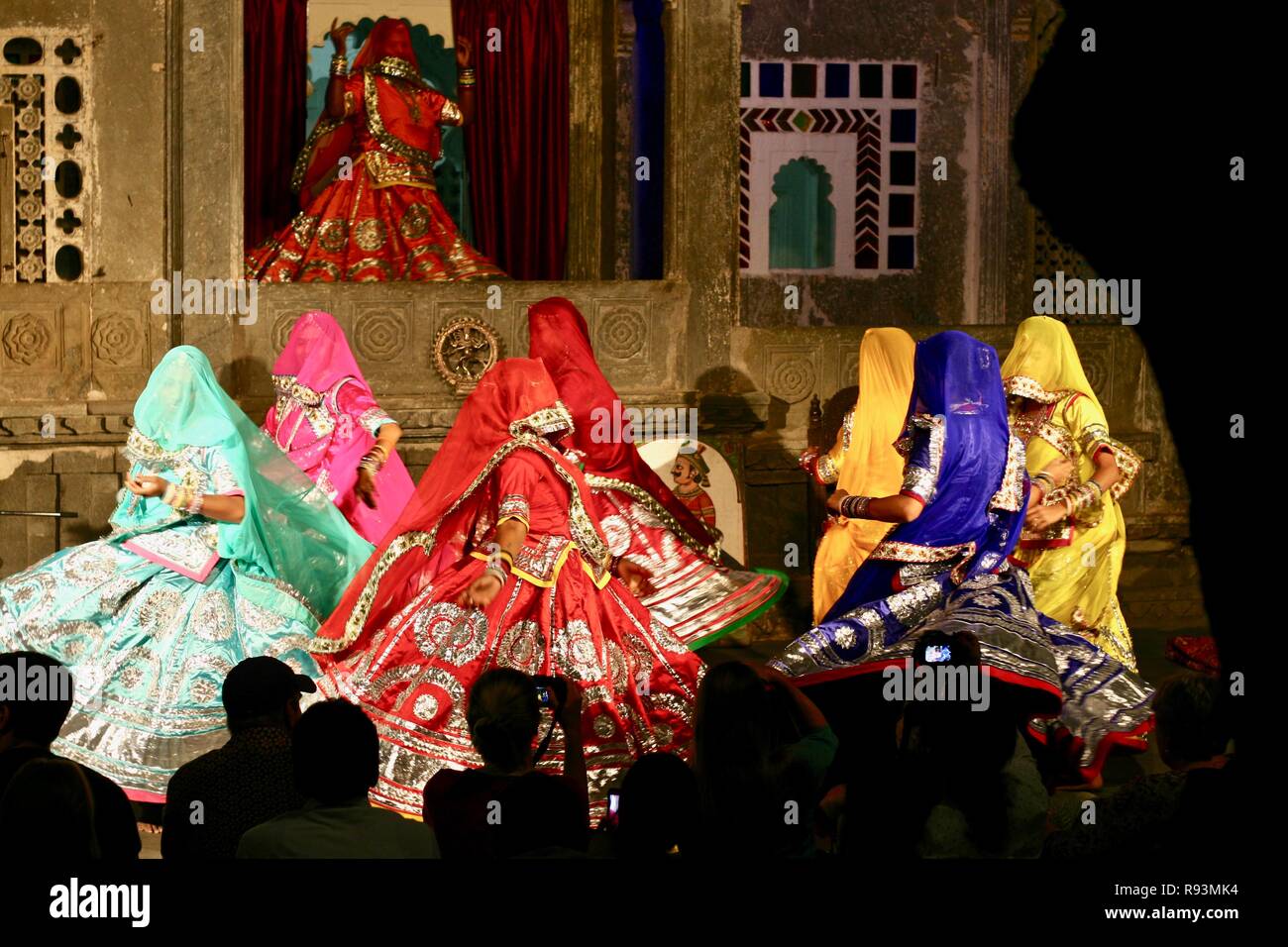 Beautiful royal dancers twirling with flared silken skirts in Udaipur, each delicately decorated with gold and silver faces covered with fine silk. Stock Photo