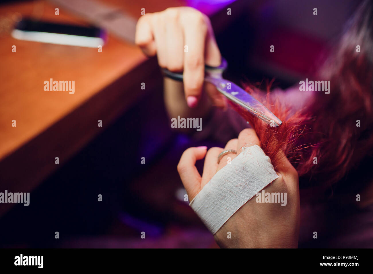 Hairdresser trimming brown hair with scissors. Haircut closeup. Getting