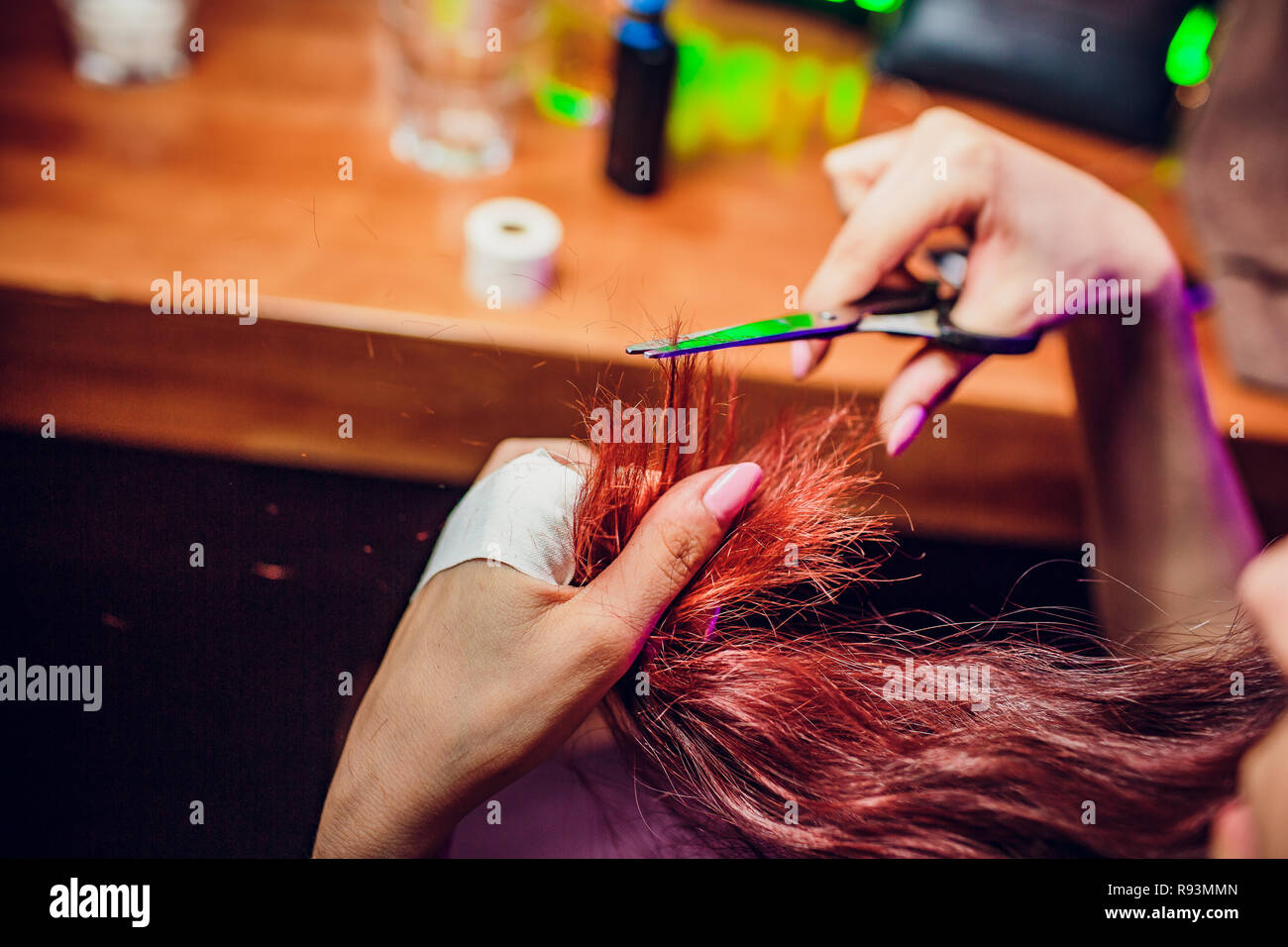 Hairdresser trimming brown hair with scissors. Haircut closeup. Getting