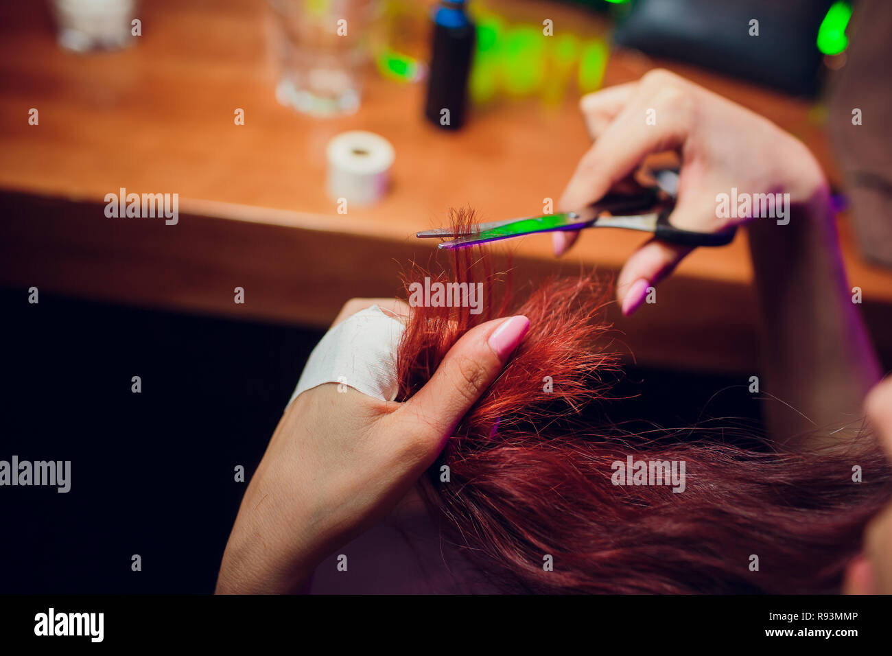 Hairdresser trimming brown hair with scissors. Haircut closeup. Getting