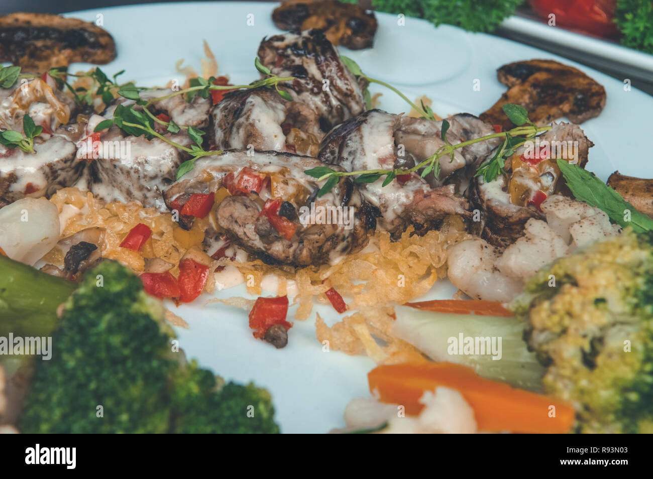 Close up of a delicious meal with baked vegetables and melted cheese in a white plate. Stock Photo