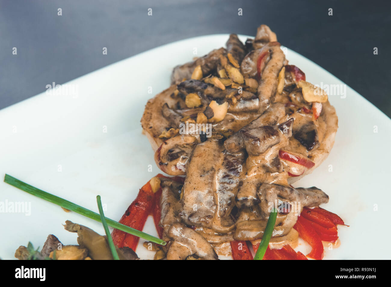 Close up of a delicious meal with baked vegetables and sauce on a white plate. Stock Photo